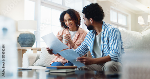 Finance  documents and happy couple with expenses in home for budget success or tax return. Man  woman or smile with paperwork for financial profit  loan approval or insurance together in house