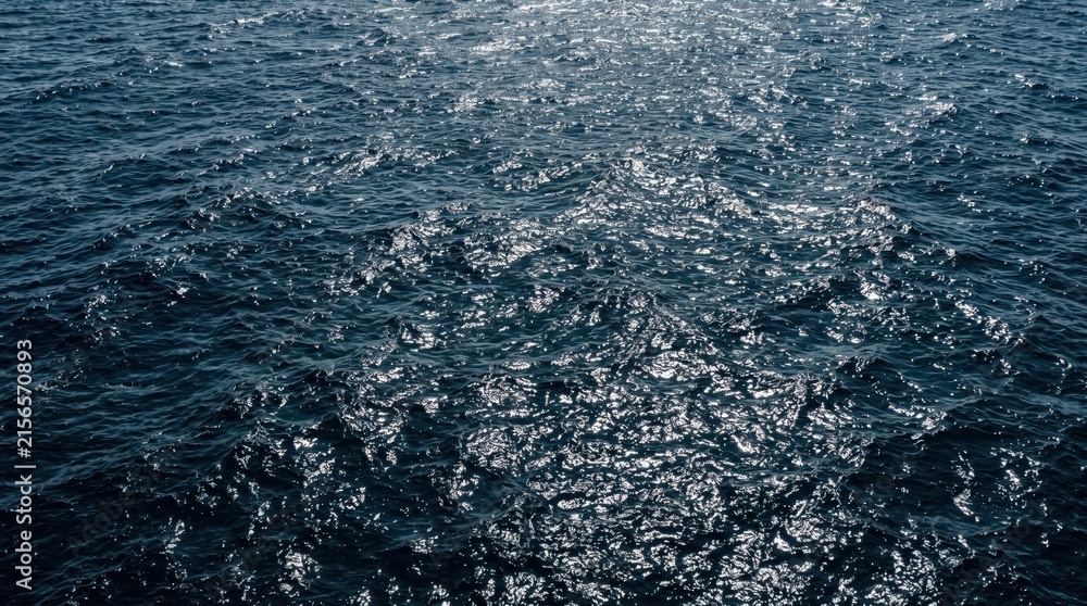 Fototapeta premium Open ocean surface with rippling waves and sunlight reflections, shimmering blue water and glinting highlights creating expansive marine seascape mood