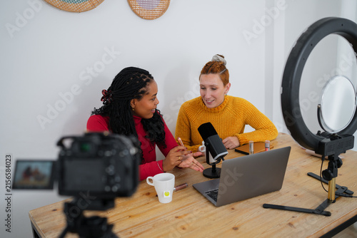 Content creators recording a podcast with camera and ring light indoors