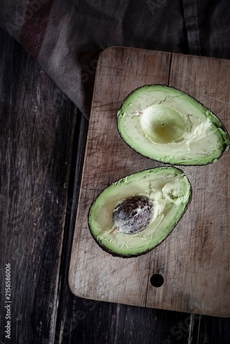 Sliced avocado on chopping board and wooden table