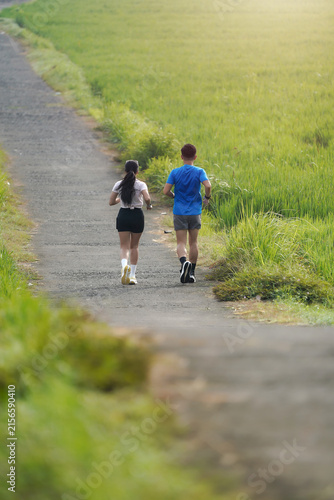 Foto Asian Indonesian Couple Running Together Along a Green Rural Road in Yogyakarta