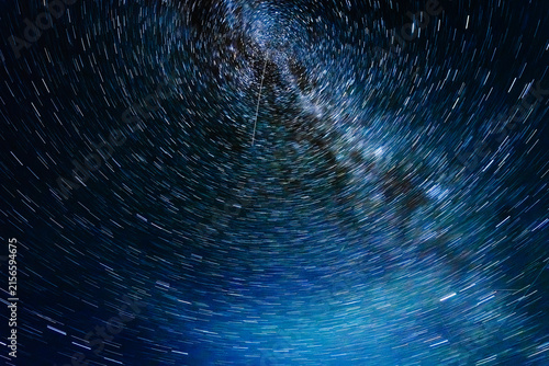 Perseid meteor shower captured in a long exposure photograph, showcasing streaking meteors against a swirling starry night sky