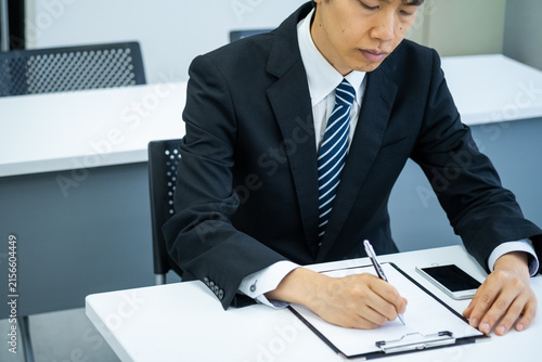 書類を記入するビジネスマン男性
