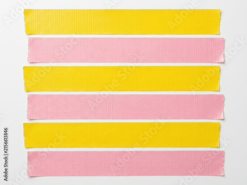 Six strips of yellow and pink textured tape laid out horizontally on white background for crafting