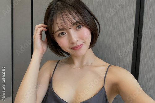 グレーのキャミソールを着る女性の室内肖像