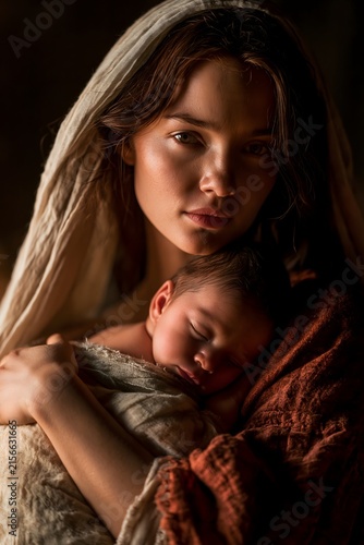 Young mother cradling her sleeping newborn baby, soft dramatic lighting, classical artistic style