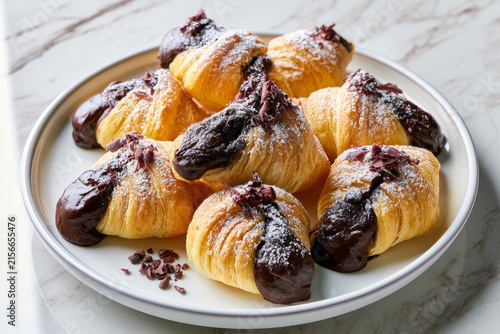 Fresh baked pastries with chocolate sauce on a plate