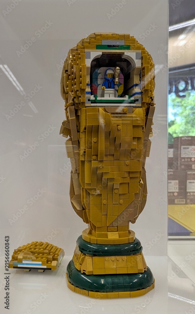 Naklejka premium Trofeo de FIFA World Cup 2026, construido con ladrillos de Lego, en expositor de una juguetería Juguettos de Madrid, España