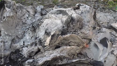 Smoldering grey ash and embers from a dying fire