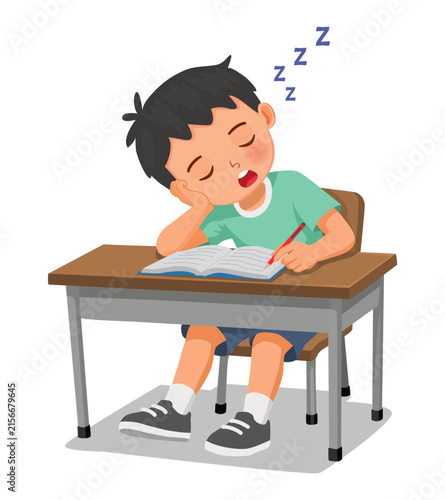 Little boy falls asleep while studying doing homework at the desk