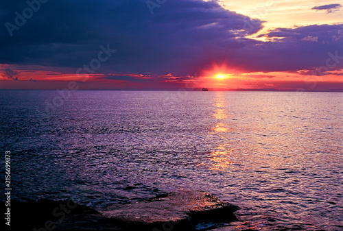 Tramonto viola sul mare con nave