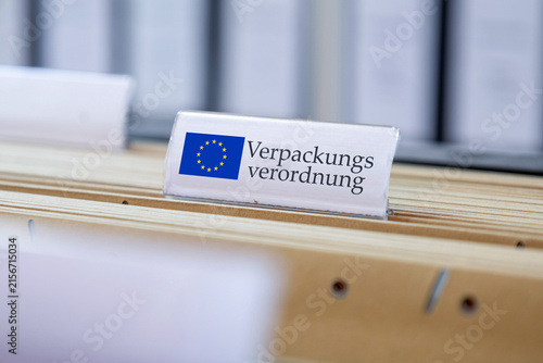(Fotomontage) Schild mit der Aufschrift VERPACKUNGSVERORDNUNG an einem Hängemappenregister