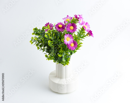 Small white vase with beautiful artificial pink flowers isolated on white
