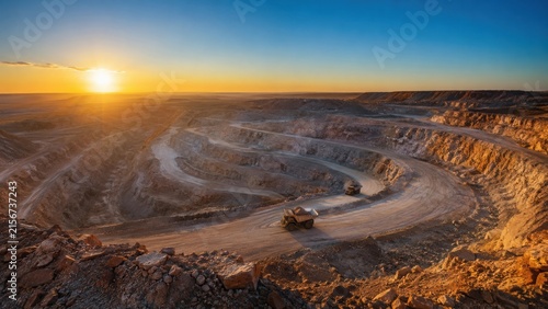 Open Pit Mining Quarry with Dump Trucks at Sunset
