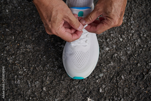 Older Adult Tying Running Shoes Before Outdoor Exercise