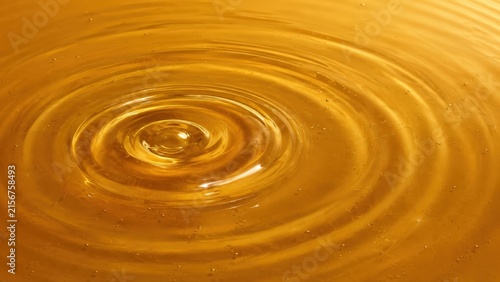 Liquid Ripples Expanding on Golden Surface