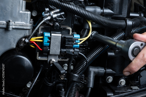 Tightening New Spark Plug During Outboard Engine Maintenance