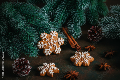 Gingerbread snowflakes and Christmas decorations on a dark rustic background, selective focus