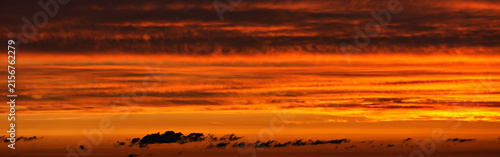 A colorful sunset in the sky with layered striped clouds