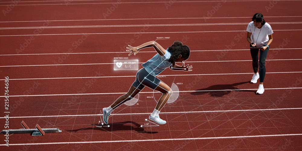 Fototapeta premium Female sprinter launching from starting blocks while coach reviews biometric and body mechanics data. Concept of smart training, coaching assessment and sprint development.