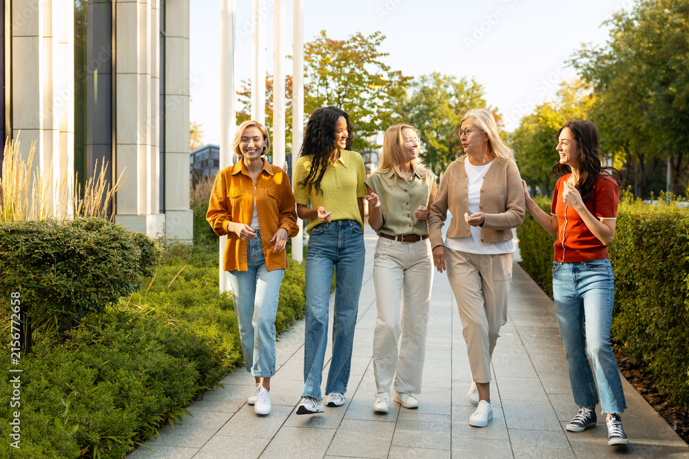 Fototapeta premium Diverse women friends walking and talking together outdoors