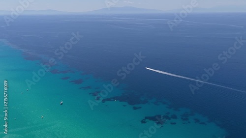 Motorboat crossing turquoise and deep blue Greek waters