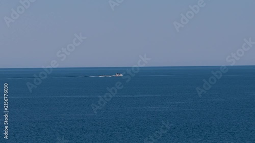 Speedboat traveling across open Greek waters beneath a clear