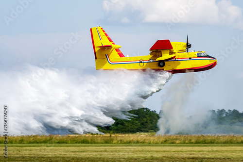 Water bomber aircraft releasing water during aerial firefighting