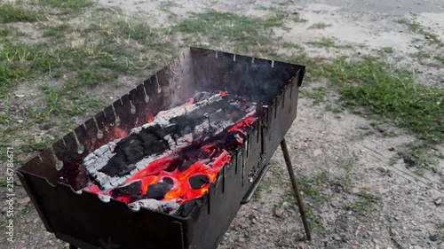 Smoldering firewood glowing inside outdoor grill