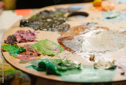 Fotografie Close-up view of a wooden artist palette covered in colorful oil paint dollops a