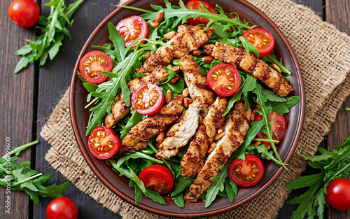 Fresh salad with chicken breast, arugula and tomato. Top view