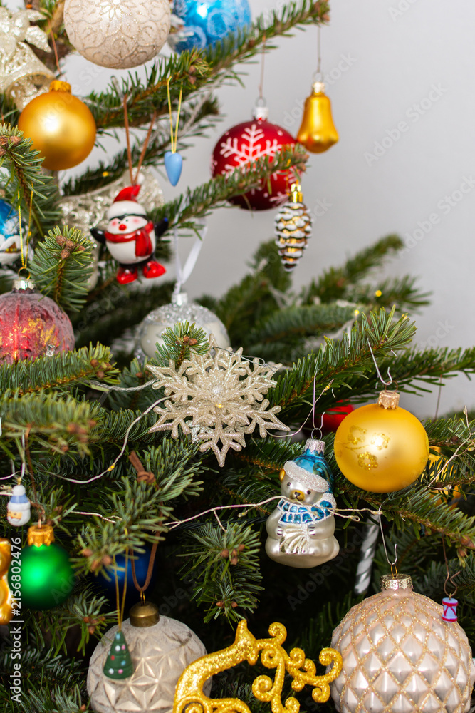 Fototapeta premium A Christmas tree stands with many colorful ornaments hanging from its branches. Each ornament shows different shapes and colors, celebrating the festive season and bringing joy to the home