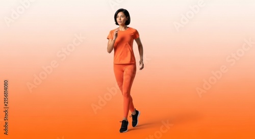 Active Woman in Orange Sportswear Walking on Gradient Orange Background