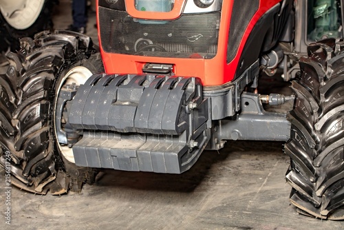 Tractor with large wheels and front attachment for farming work in a barn