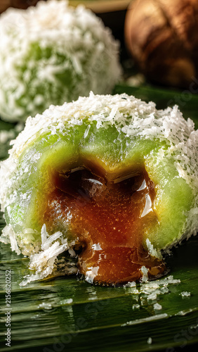 Macro cutaway of a coconut covered klepon showing glossy melted palm sugar filling.generative AI