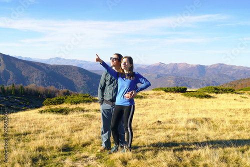 Quadro su tela Couple stands against backdrop of Montenegrin highlands, woman pointing at something