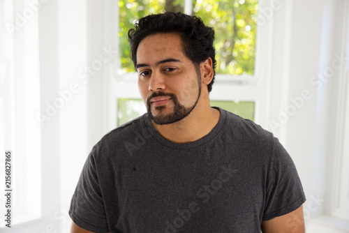 Photography African American mid-adult man wearing dark gray tee standing by multi-pane wind