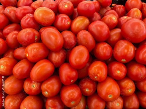 A bin full of fresh tomatoes for sale at a supermarket