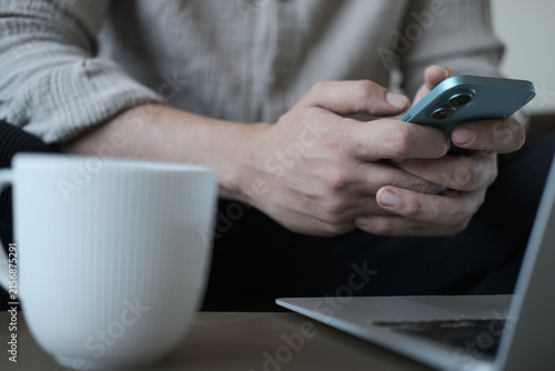 Close-up of a person using working on a laptop with coffee at a modern workspace.