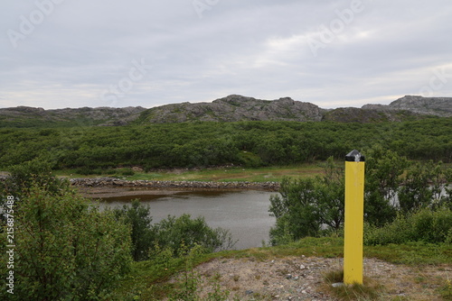 Obraz na płótnie Yellow border marker viewed from the Norwegian side near the Norway-Russia border