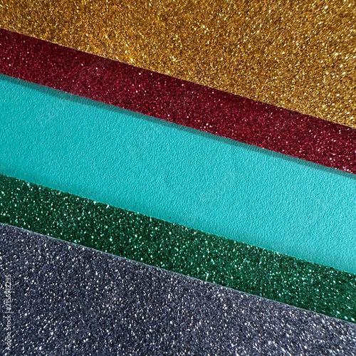 Diagonal stripes of glittering paper in gold, red, teal, green, and silver