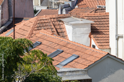 Obraz na plátně Urban rooftops with terracotta tiles and skylights in europe