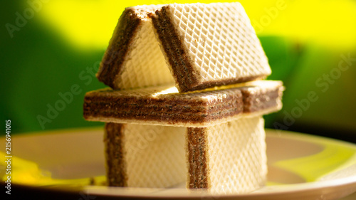Close-up, macro shot of waffles stacked in a house on a bright green background.