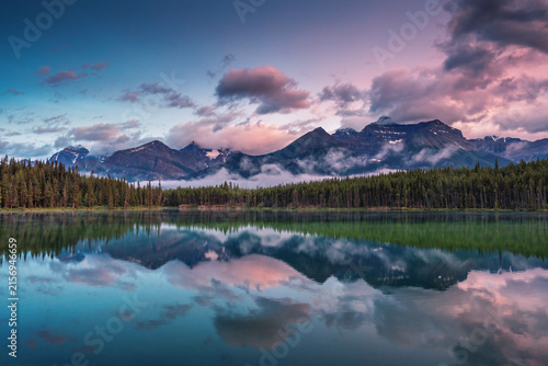 Принти на полотні Symmetrical mountain reflection at Herbert Lake during purple sunset in Banff Ca