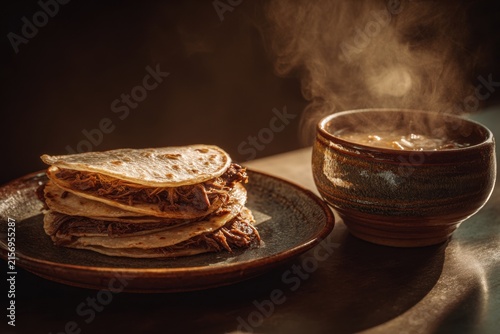 mexican taco stack with beef filling and crispy tortilla next to steaming broth bowl, herb garnish on plate in warm moody lighting, close up food composition, restaurant, food blog, delivery