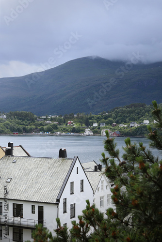 Alesund city roofs, ocean bay and surrounding mountains, Norway. Scandinavian cityscape with traditional coastal houses.