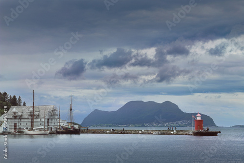 Molja lighthouse under stormy skies in Alesund, Norway. The Crimson Beacon of Ålesund in the Norwegian Fjord.