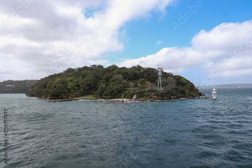 Coastal Headland with Lighthouse and Green Trees Over Blue Ocean