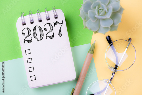 New year resolutions 2027 on desk. 2027 goals list with notebook, coffee cup, plant. Resolutions, plan, goals, action, checklist, idea concept. New Year 2027 resolutions, copy space