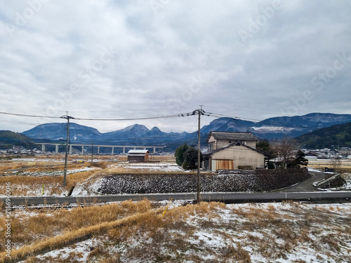 Rural Japanese Village with Snow-Capped Mountains in Winter Countryside